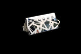 Custom humbucker pickup with a black and white geometric pattern cover on a dark background.